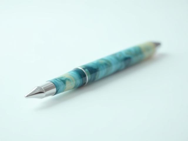 Vibrant fountain pen made from a blue and green swirled recycled ocean plastic resin, mimicking waves.
